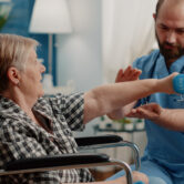 physiotherapy for elderly patient doing guided exercises with therapist