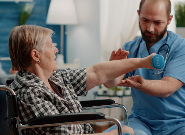 physiotherapy for elderly patient doing guided exercises with therapist