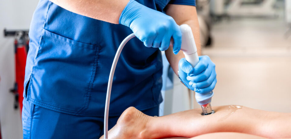 Physiotherapist performing ESWT shockwave therapy on patient knee in Vaishali
