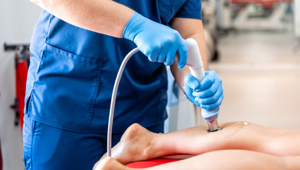 Physiotherapist performing ESWT shockwave therapy on patient knee in Vaishali